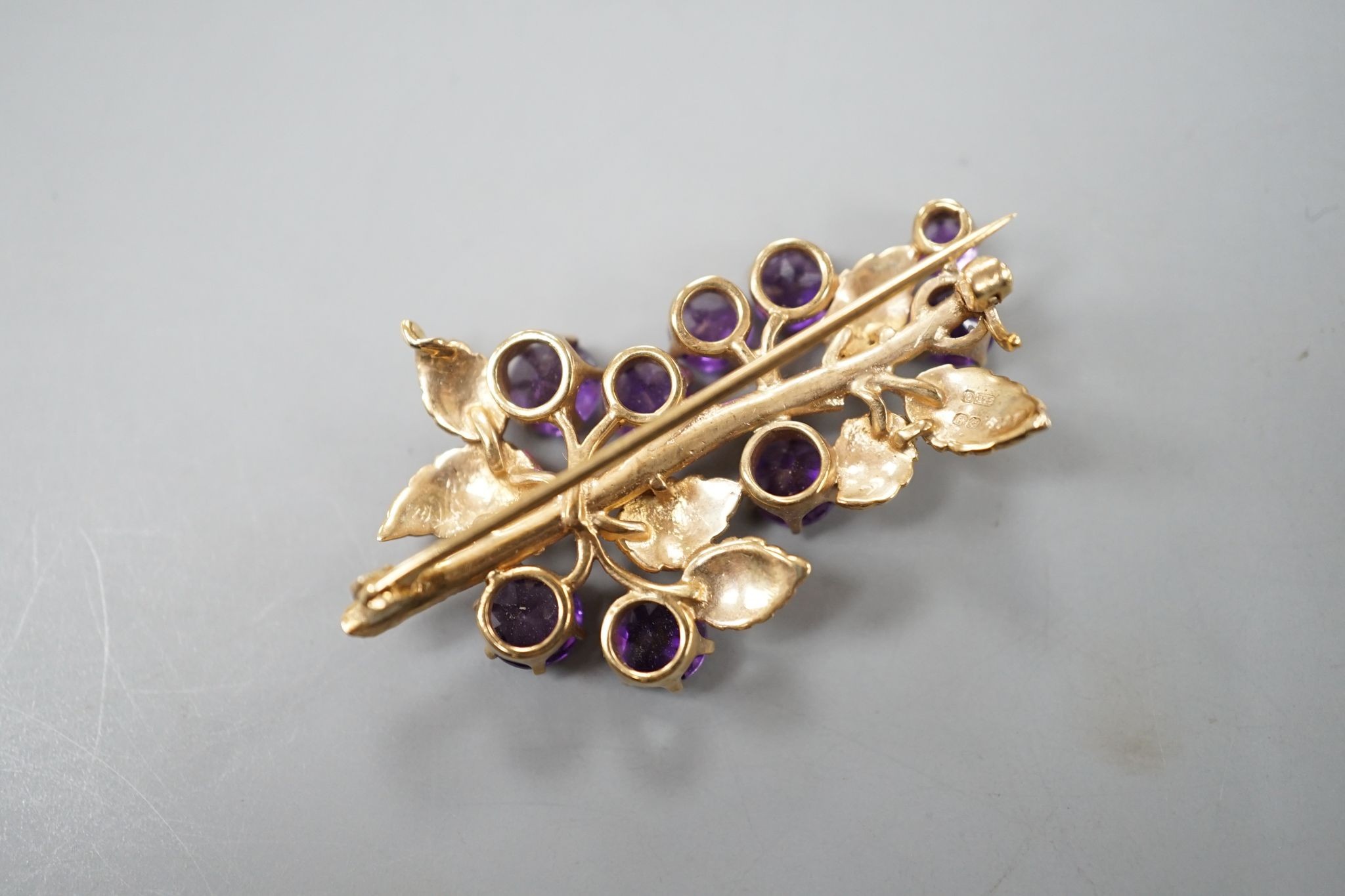 A modern 9ct gold and nine stone amethyst set spray brooch, 42mm, gross 7.6 grams, in fitted box.